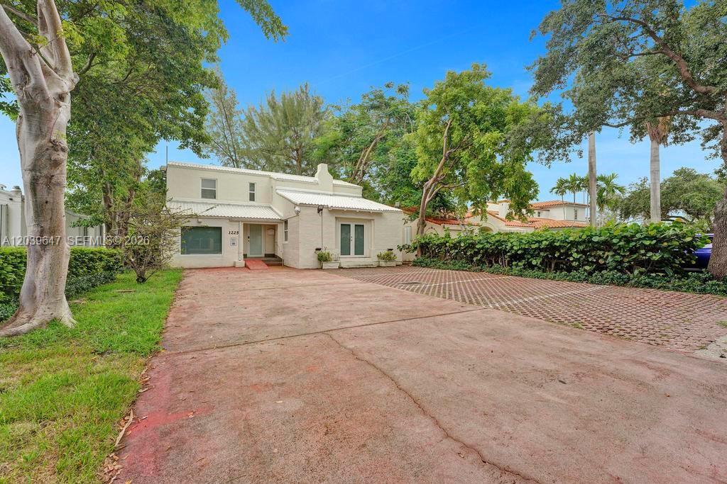 A two-story white house with a large concrete and paver driveway surrounded by trees — 1225 Alton Rd, Miami Beach FL 33139, MIAMI BEACH, FL