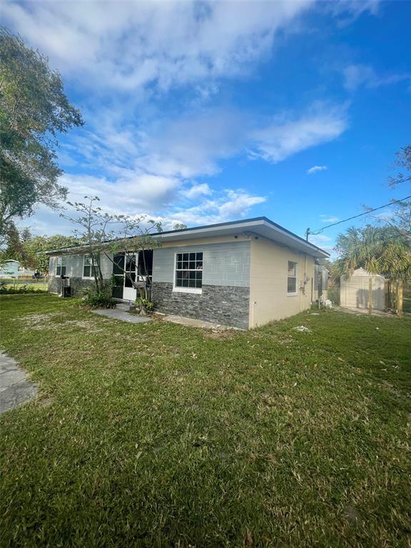 A single-story house with a flat roof, stone veneer, and a screened-in front porch — 3995 40TH STREET N, ST PETERSBURG, FL