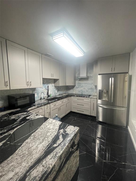 A kitchen features light gray cabinets, black and white stone countertops, and black tile flooring — 3995 40TH STREET N, ST PETERSBURG, FL