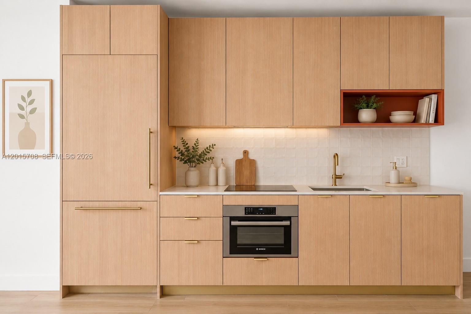 A modern kitchen features light wood cabinetry, gold hardware, a built-in oven, and white tile — 90 NE 32nd # 313, Miami FL 33137, MIAMI, FL