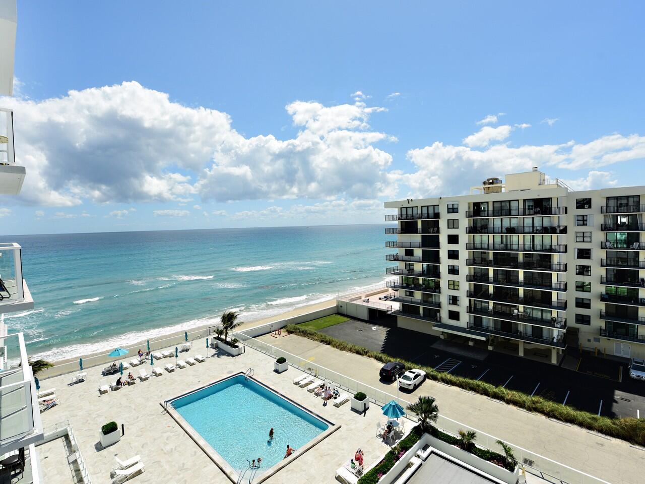 A high-angle view from a balcony overlooking a swimming pool, beach, and ocean — 3450 S Ocean Boulevard # 712, Palm Beach FL 33480, PALM BEACH, FL