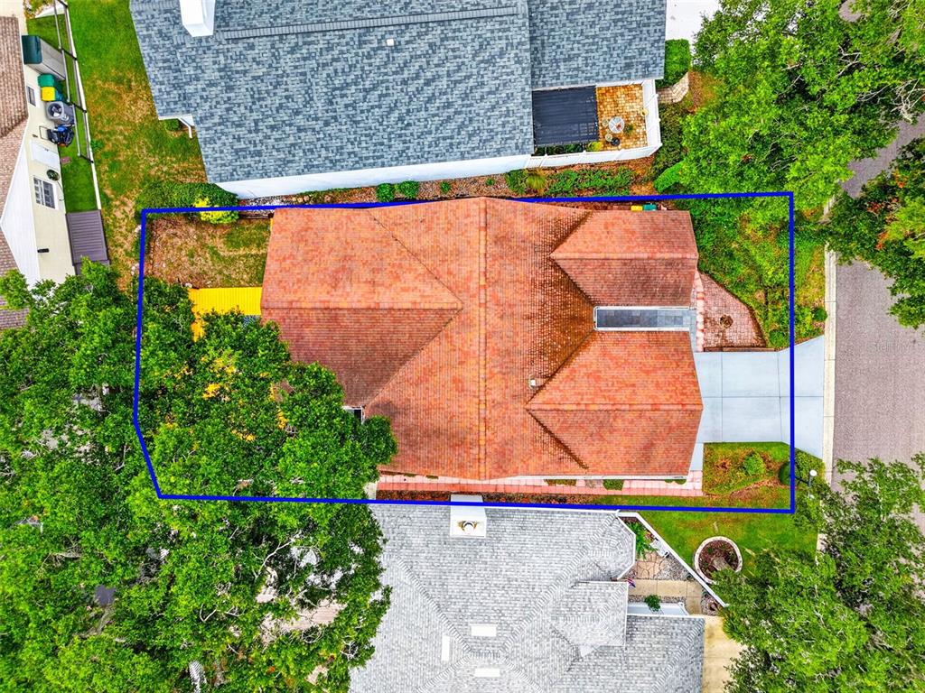An aerial view shows a house with a red tile roof surrounded by green trees — 57 TOWNHILL DRIVE, EUSTIS, FL