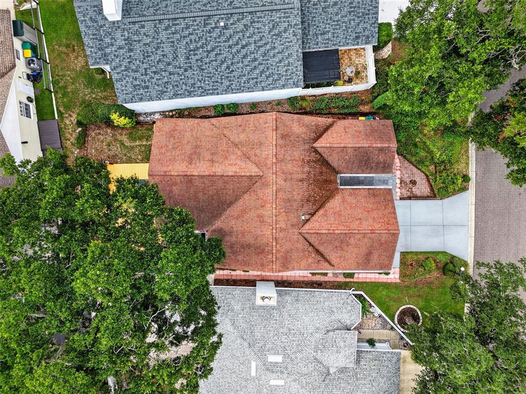 An aerial view shows a house with a brown shingled roof between two neighboring homes — 57 TOWNHILL DRIVE, EUSTIS, FL