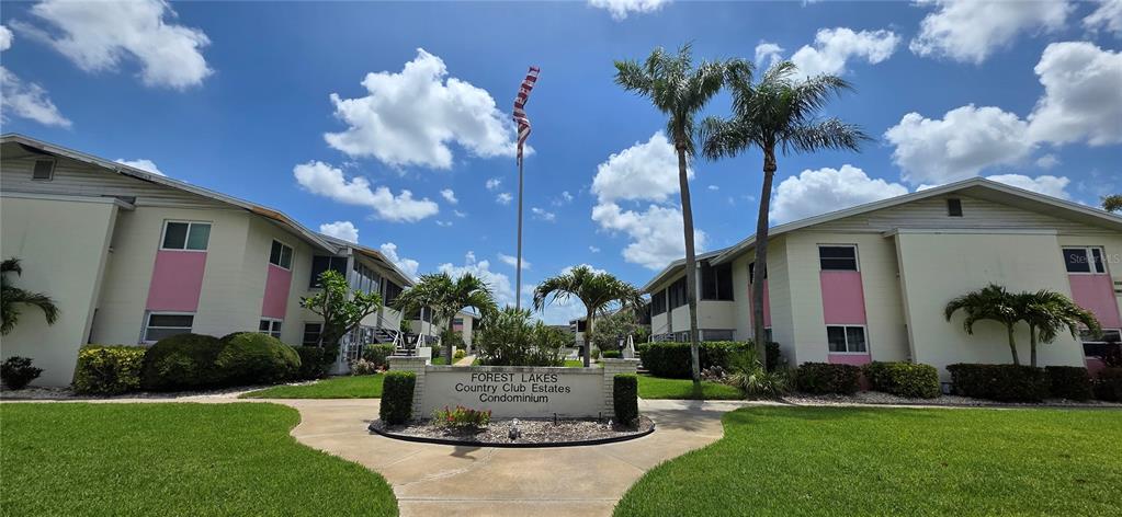 The exterior of a condominium complex features two buildings with pink accents and palm trees — 2507 BENEVA ROAD UNIT 5, SARASOTA, FL