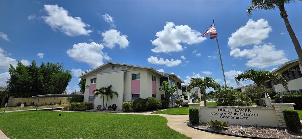 The exterior of a two-story condominium building features pink accents and a prominent entrance sign — 2507 BENEVA ROAD UNIT 5, SARASOTA, FL