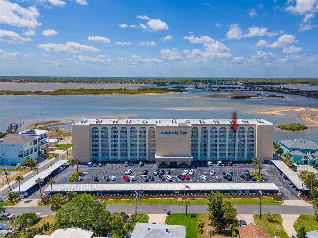 An aerial view shows the Admiralty Club condominium building with a red arrow pointing to a unit — 3606 S PENINSULA DRIVE UNIT 703, PORT ORANGE, FL