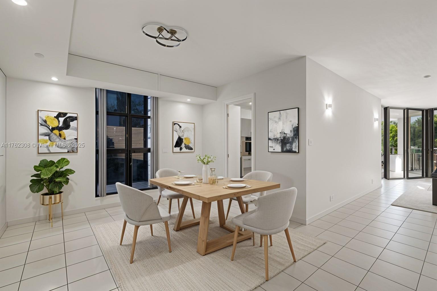 A dining room features a glass table, upholstered chairs, a modern chandelier, and mirrored walls — 4000 Towerside Ter # 302, Miami FL 33138, MIAMI, FL