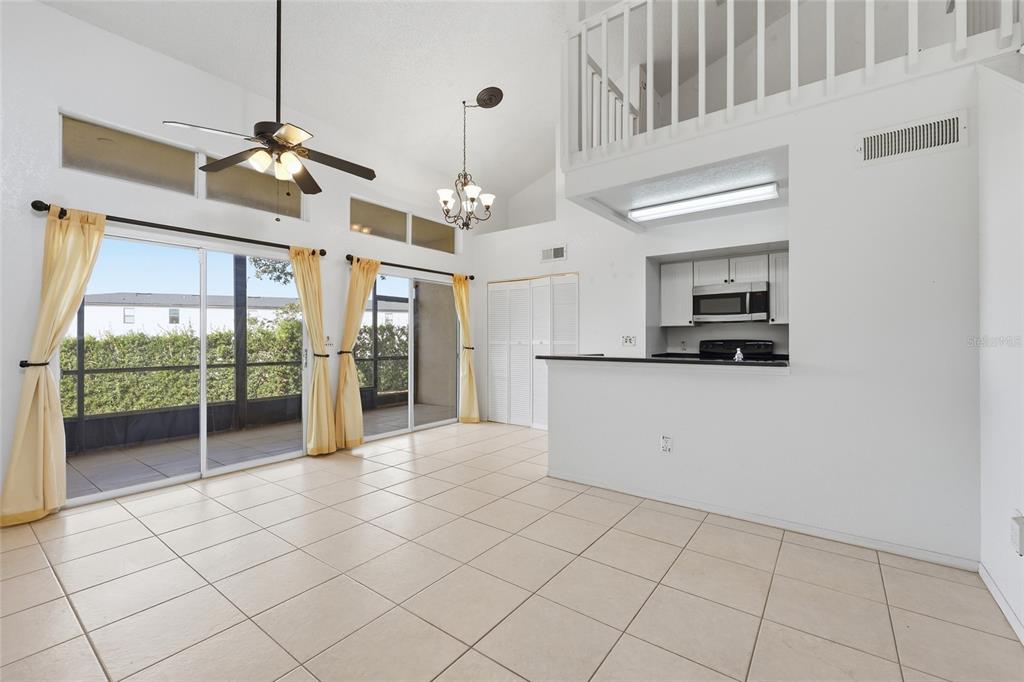 A bright dining area with tile floors, a kitchen pass-through, and sliding glass doors — 3176 TAMARIND CIRCLE UNIT 19, KISSIMMEE, FL