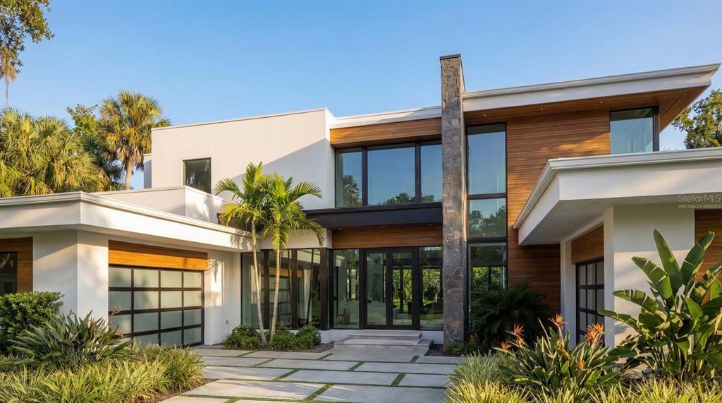 A modern two-story house features white stucco, wood siding, large windows, and a stone chimney — 9671 BLANDFORD ROAD, ORLANDO, FL