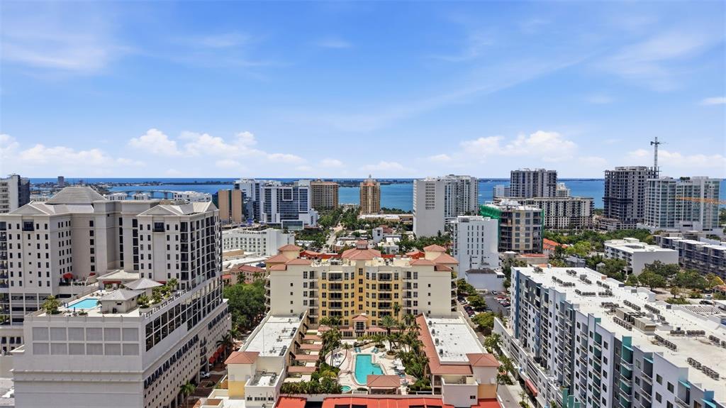 An elevated view of a coastal city featuring multiple high-rise buildings and a swimming pool — 100 CENTRAL AVENUE UNIT H716, SARASOTA, FL