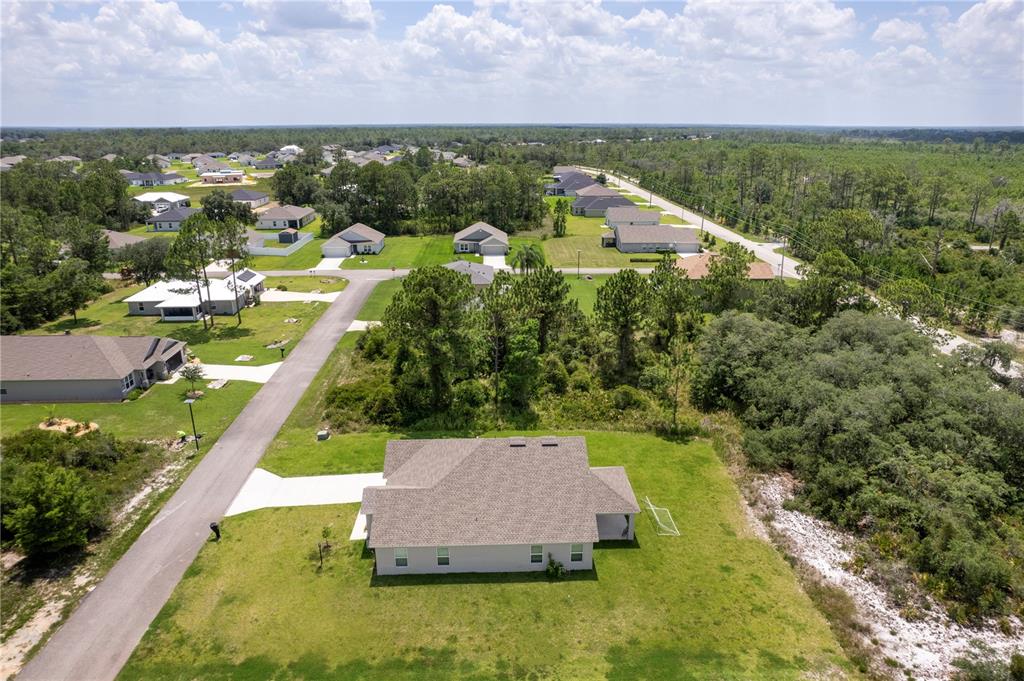 An aerial view shows a single-story house with a gray roof on a grassy lot — 5236 SUE DRIVE, SEBRING, FL