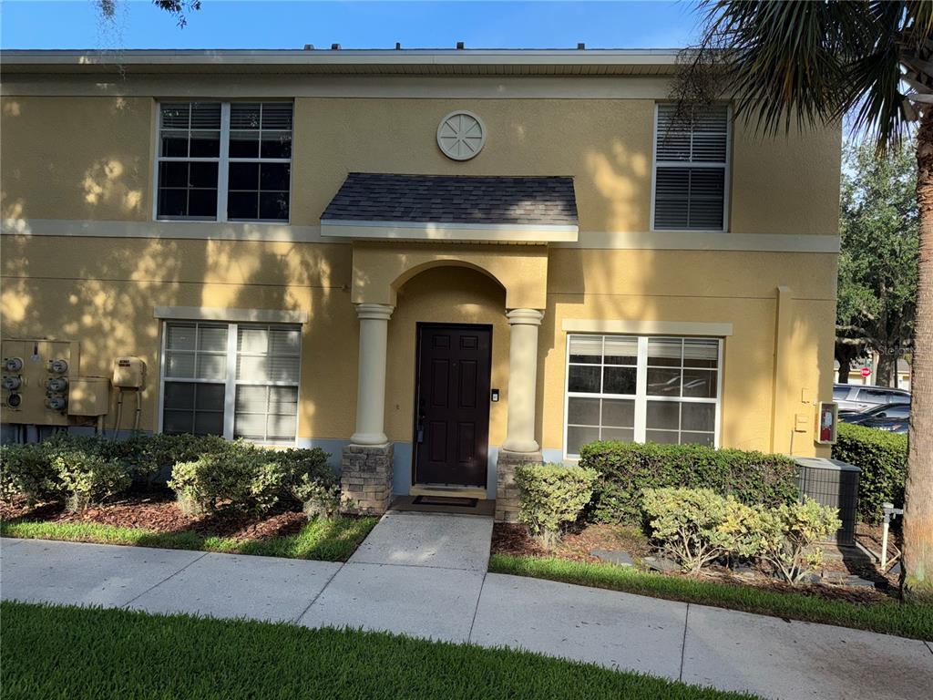 A two-story yellow stucco building with a covered entryway and stone-based columns — 37603 DALIHA TERRACE, ZEPHYRHILLS, FL