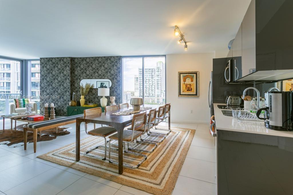 A dining area with a wooden table and chairs sits adjacent to a modern kitchen — 31 SE 6th St # 1601, Miami FL 33131, MIAMI, FL