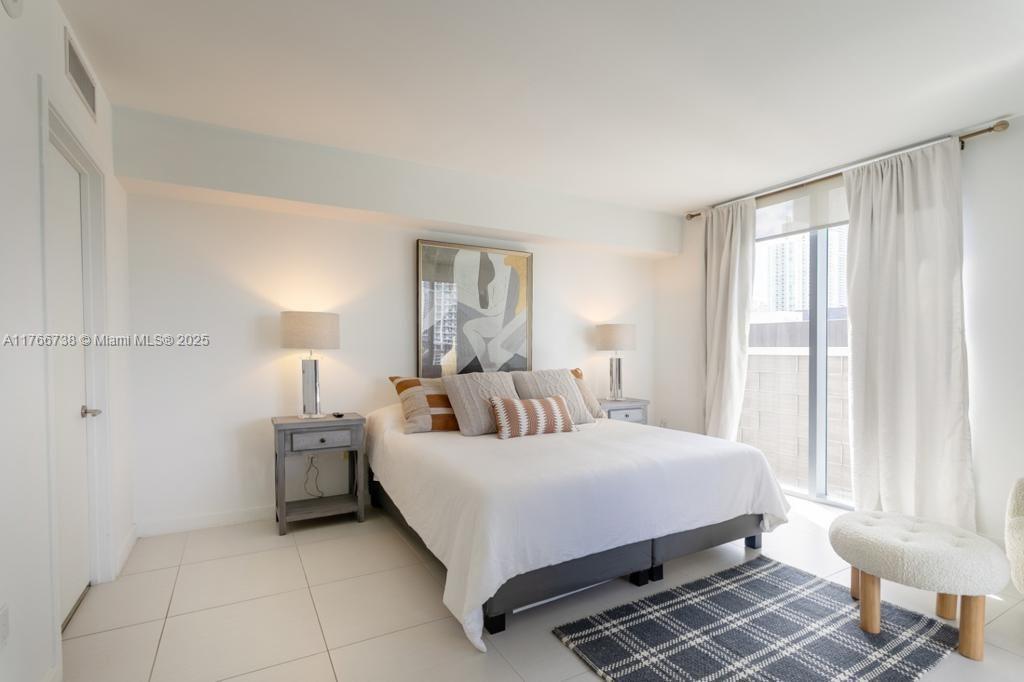 A bedroom features a queen bed, two nightstands with lamps, and a window with curtains — 31 SE 6th St # 1601, Miami FL 33131, MIAMI, FL