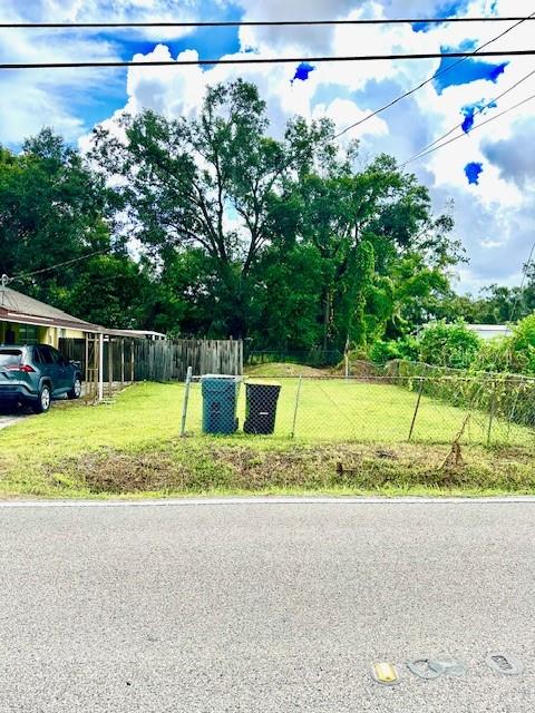 A vacant, fenced-in residential lot sits next to a house with a parked car — 904 SOUTHERN AVENUE, LAKELAND, FL