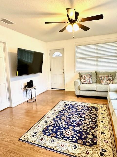 A living room features a ceiling fan, a wall-mounted television, and a patterned area rug — 904 SOUTHERN AVENUE, LAKELAND, FL