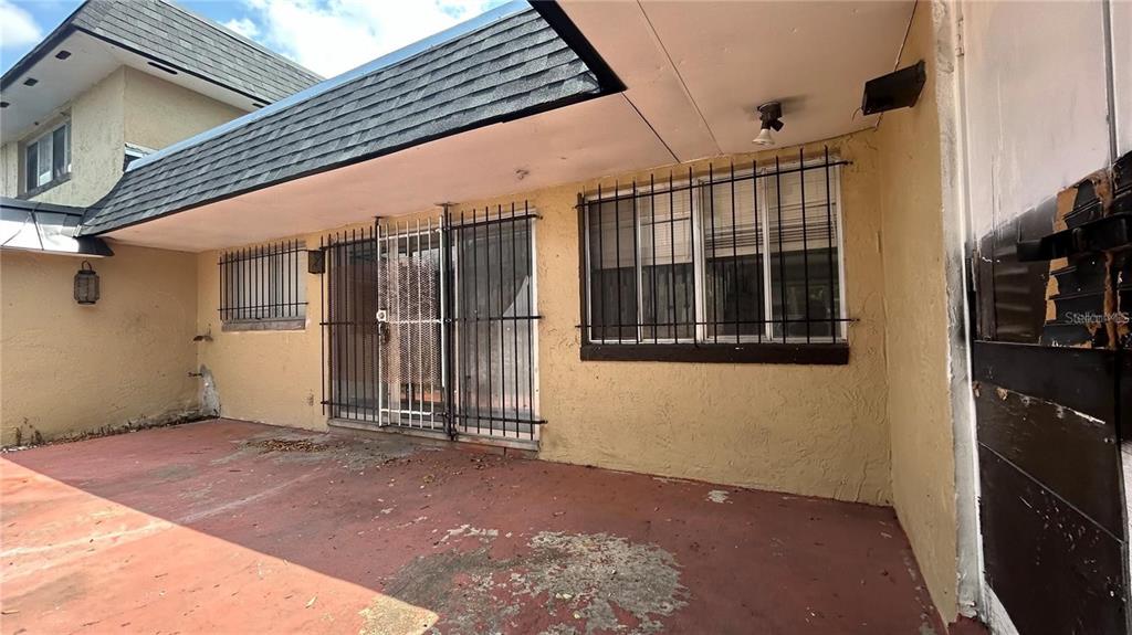 A covered patio with a concrete floor, stucco walls, and security bars on the windows — 2235 SILVER PINES PLACE UNIT 401, ORLANDO, FL