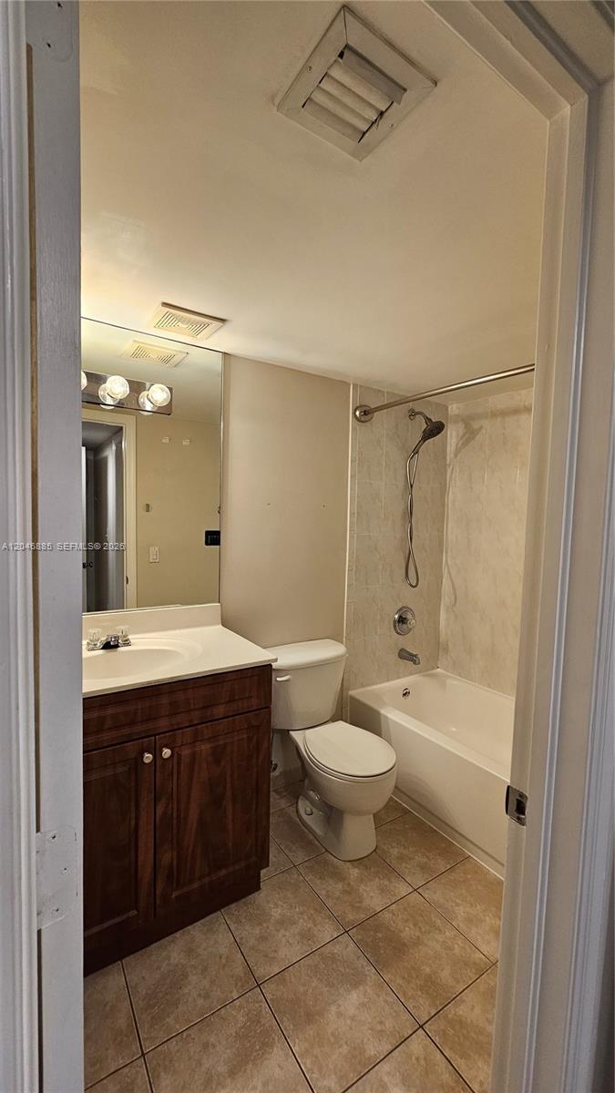 A bathroom features a vanity with a dark wood cabinet, toilet, and shower-tub combination — DAVIE, FL