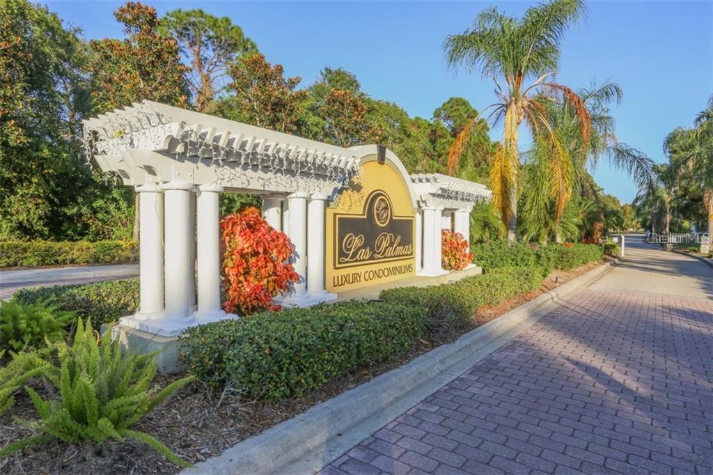 A stone entrance sign for Las Palmas Luxury Condominiums stands beside a paved driveway — 5655 BENTGRASS DRIVE UNIT 9-117, SARASOTA, FL