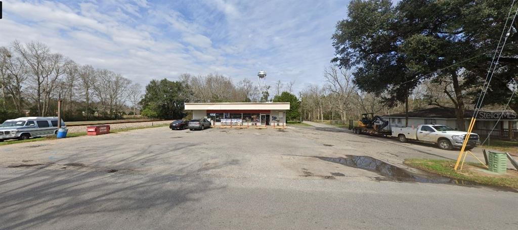 A commercial building with a large parking lot and a water tower in the background — 10 WILLIAMS DITCH ROAD, CANTONMENT, FL