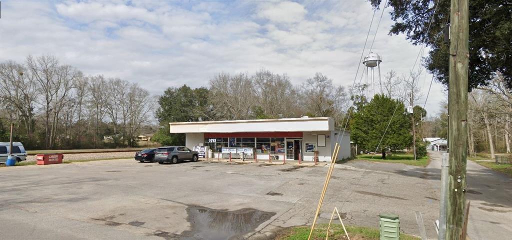 A single-story commercial building with a large parking lot and a water tower nearby — 10 WILLIAMS DITCH ROAD, CANTONMENT, FL