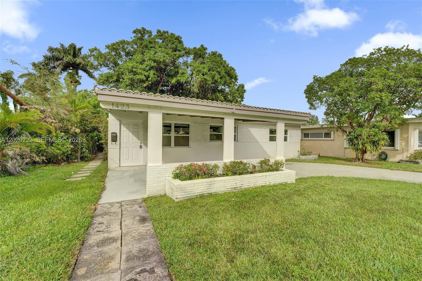 A single-story house with a covered front porch, white brick facade, and a grassy lawn — 1423 Garfield St, Hollywood FL 33020, HOLLYWOOD, FL