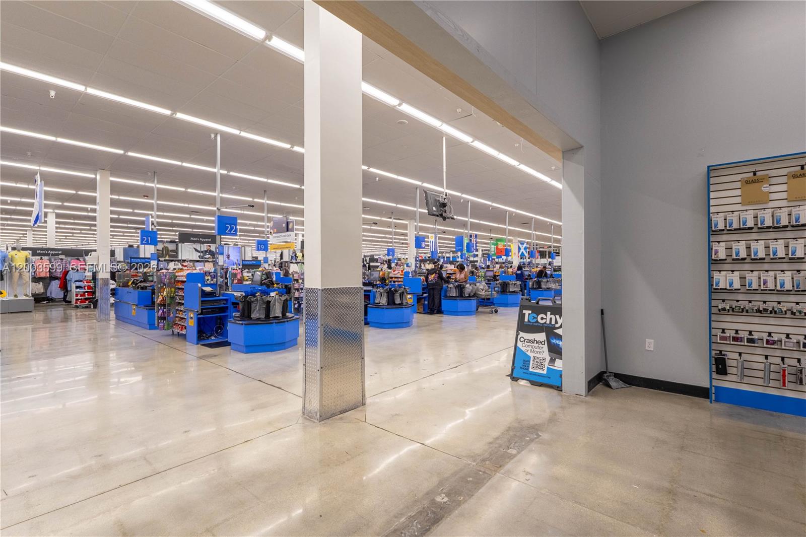 A wide-angle view of a retail store interior featuring checkout lanes and product displays — 1800 S University Dr, Miramar FL 33025, MIRAMAR, FL