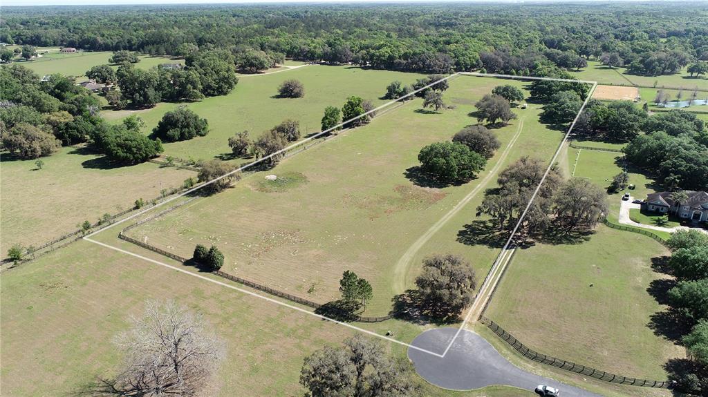 An aerial view shows a large, fenced rectangular plot of land with scattered mature trees — TBD SW 104TH  ST ROAD, OCALA, FL