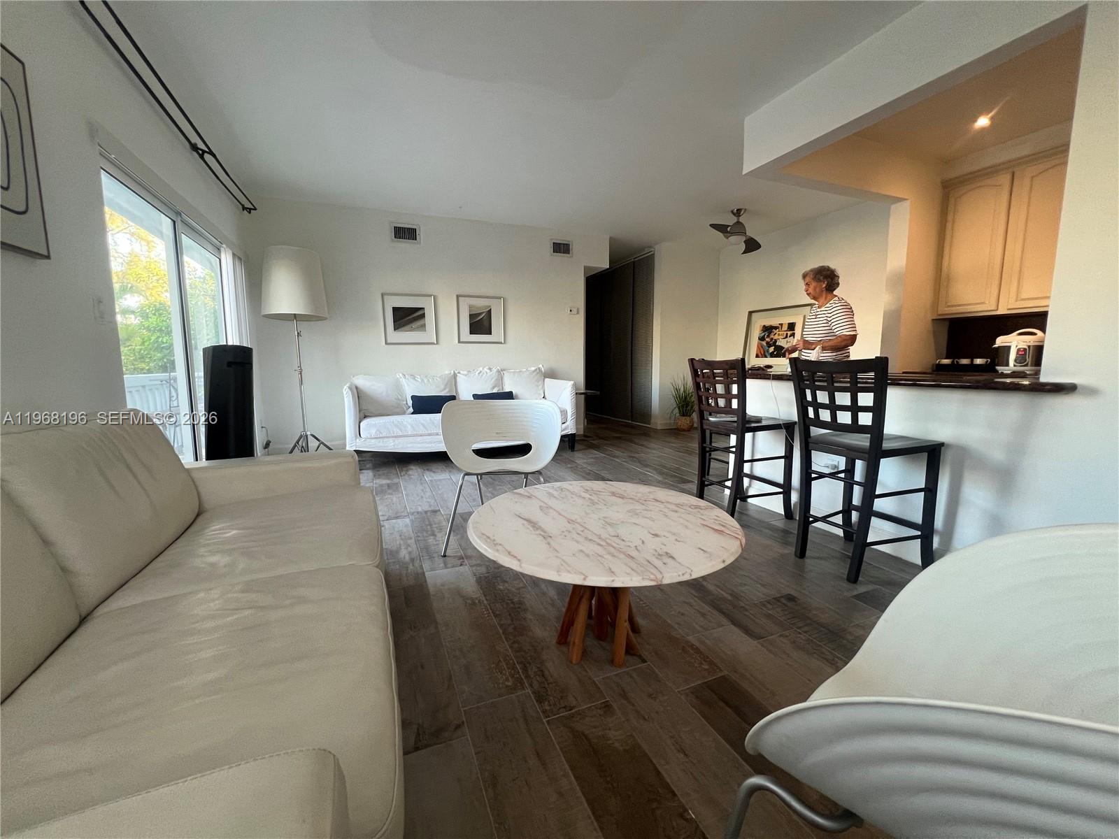 A living room with a white sofa, marble coffee table, and an open kitchen area — 1334 Euclid Ave # 7, Miami Beach FL 33139, MIAMI BEACH, FL