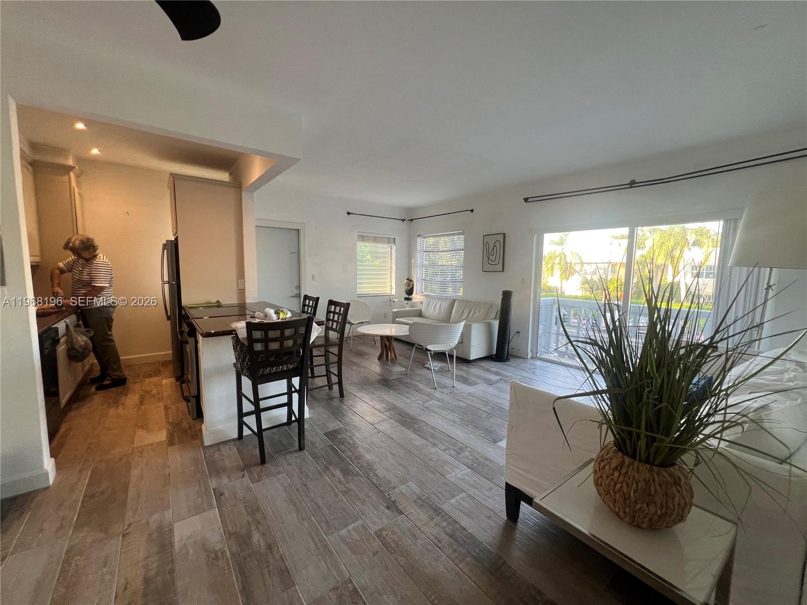 An open-concept living area features a kitchen with a breakfast bar and wood-look tile flooring — 1334 Euclid Ave # 7, Miami Beach FL 33139, MIAMI BEACH, FL