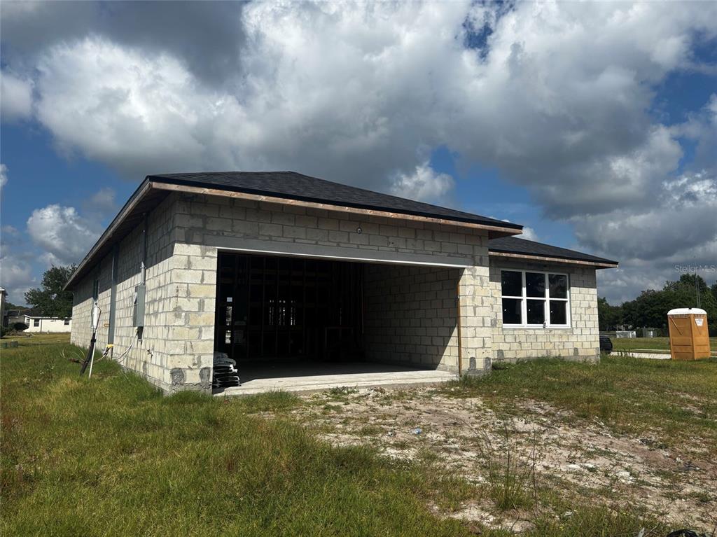 A single-story house under construction with concrete block walls and a dark shingled roof — 2651 TRAFALGAR BOULEVARD, KISSIMMEE, FL