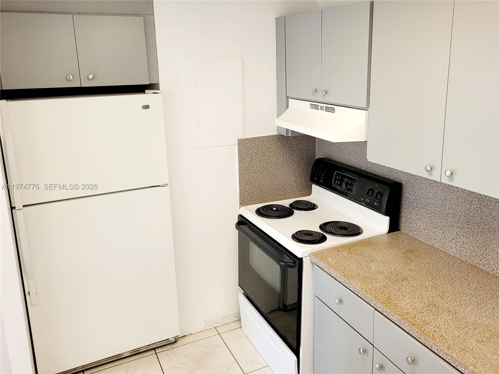A kitchen features a white refrigerator, a white electric stove, and gray cabinets — 1700 NE 191st St # 402, Miami FL 33179, MIAMI, FL