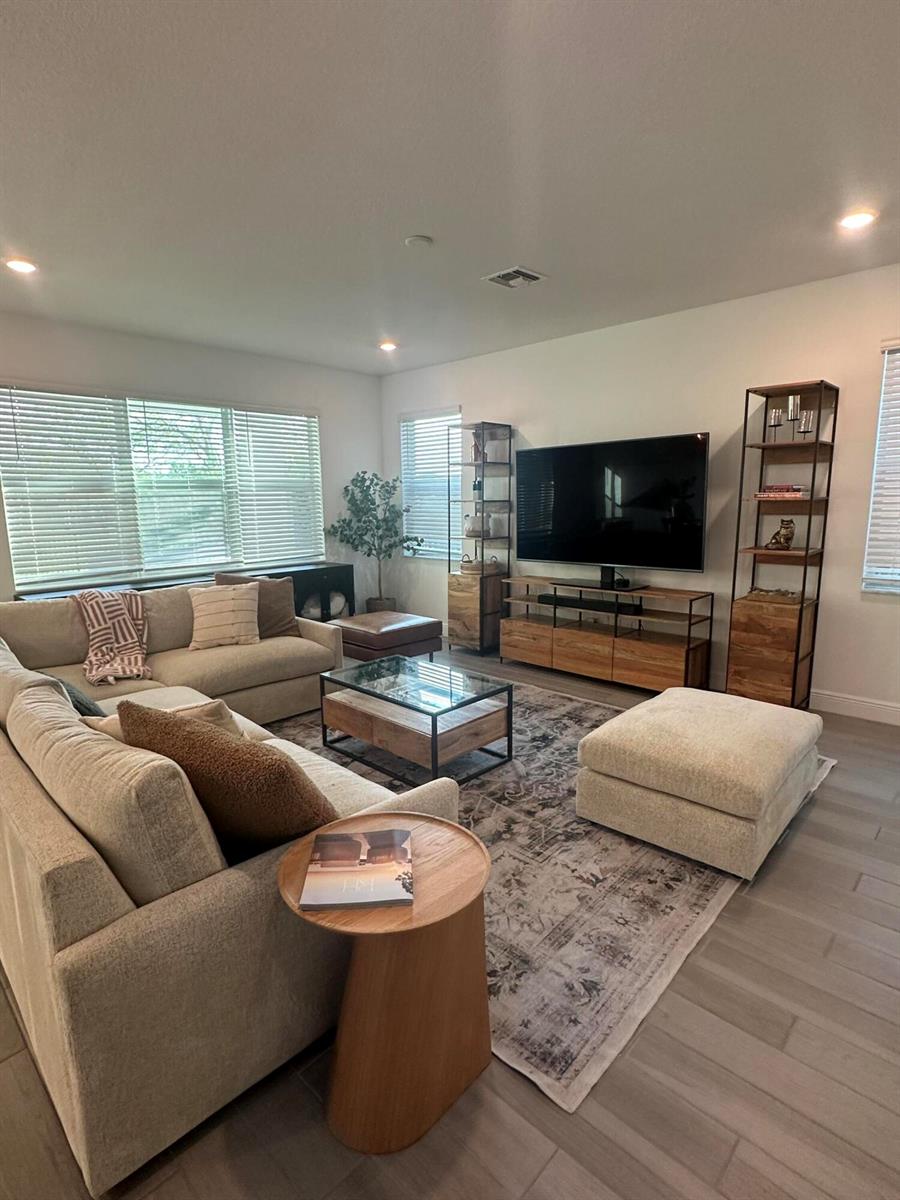 A living room features a sectional sofa, a glass-top coffee table, and a television console — 1131 Verde Court, Deerfield Beach FL 33064, DEERFIELD BEACH, FL