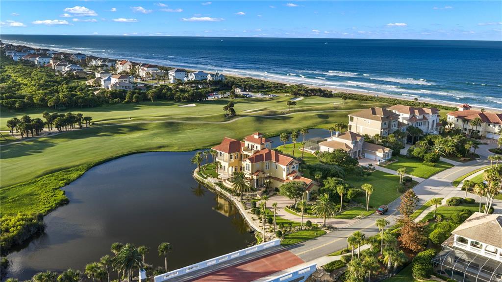 An infinity pool and spa overlook a lake and golf course at sunset — 501 GRANADA DRIVE, PALM COAST, FL