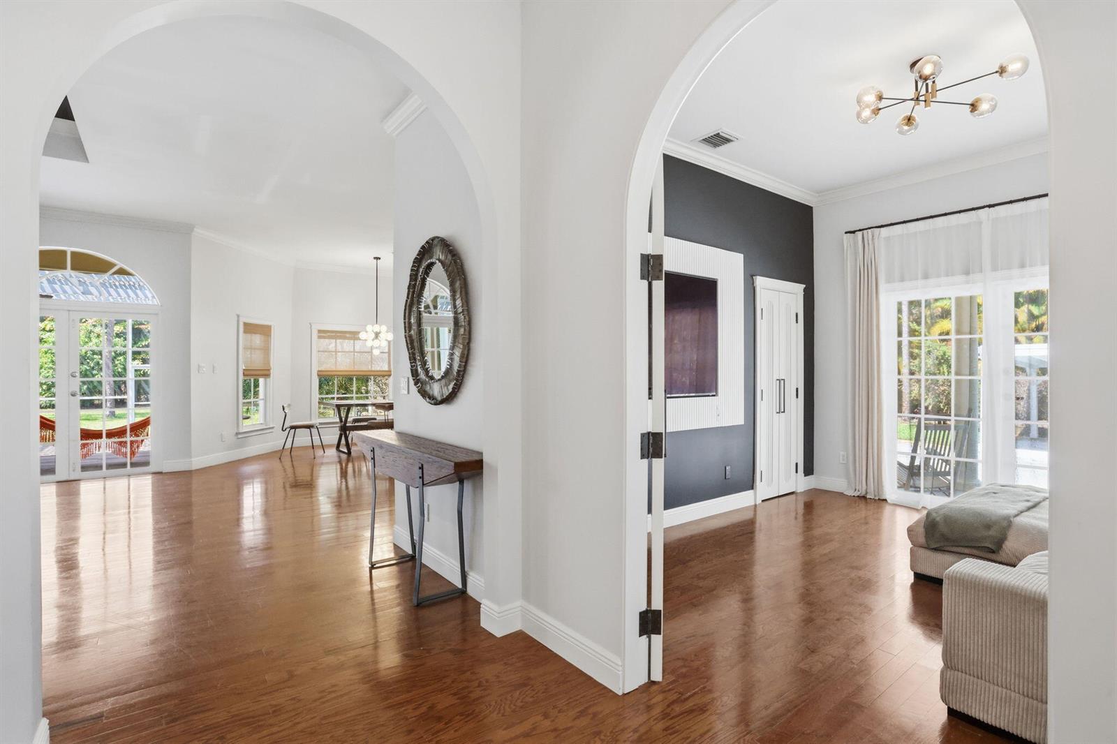 An interior view shows two arched doorways leading to rooms with hardwood floors and windows — 17241 N 123rd Ter Terrace N, FL 33478, FL