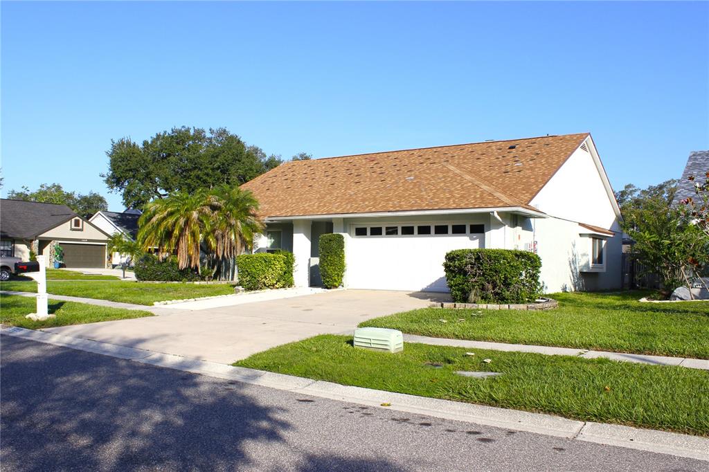 A single-story house with a white exterior, a brown shingled roof, and a two-car garage — 1913 FIRETHORN COURT, BRANDON, FL