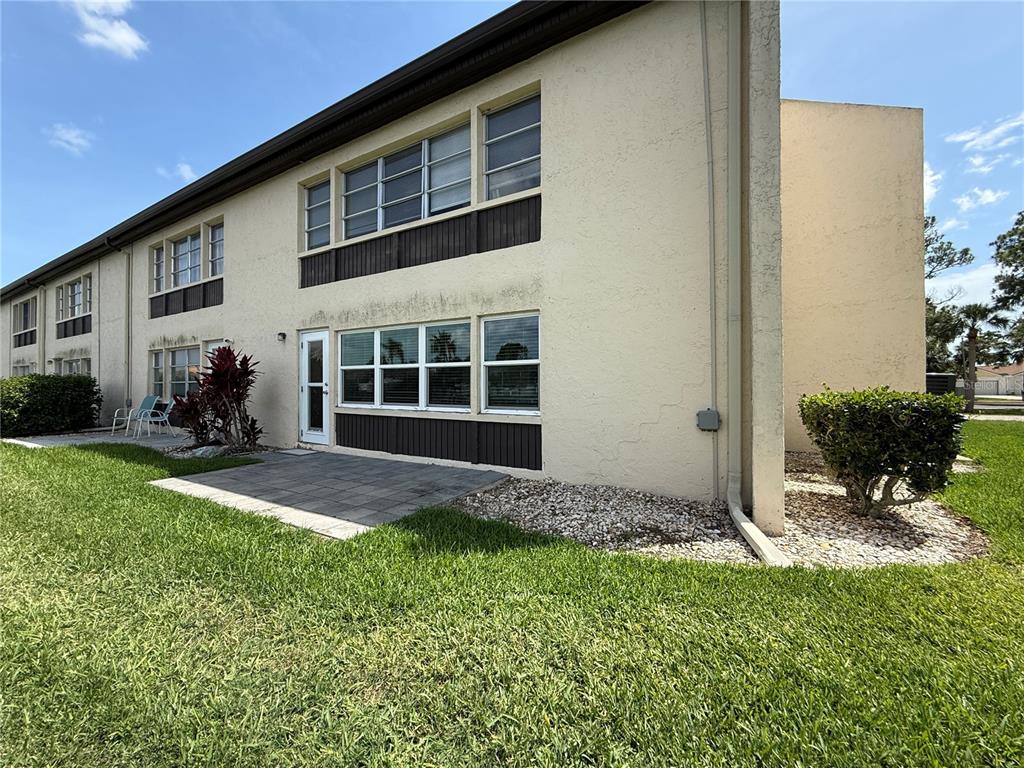 A two-story apartment building exterior with a paved patio and a grassy lawn — 4533 MARINE PARKWAY UNIT 101, NEW PORT RICHEY, FL