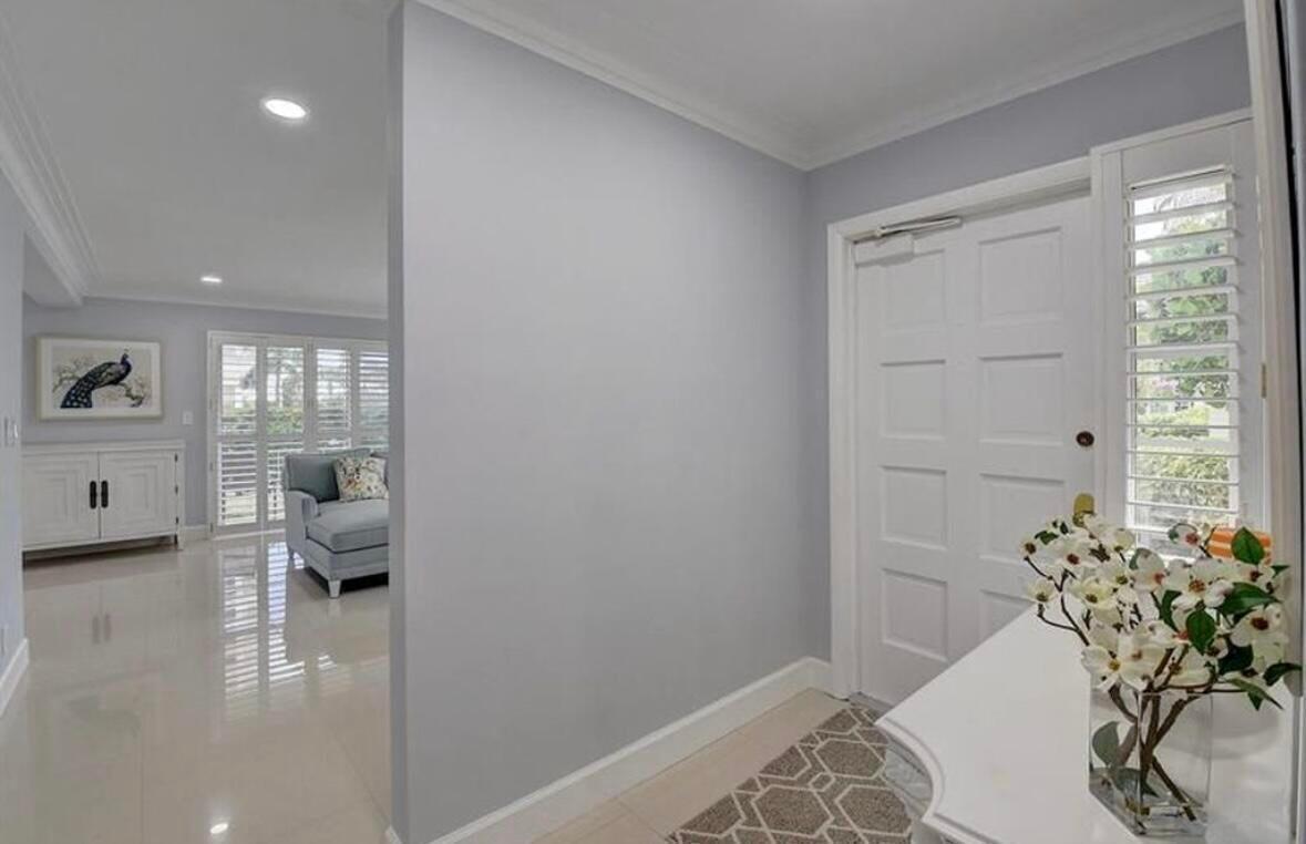 A bright entryway features light gray walls, white trim, tile flooring, and a white door — 1299 S Ocean Boulevard # L5, Boca Raton FL 33432, BOCA RATON, FL