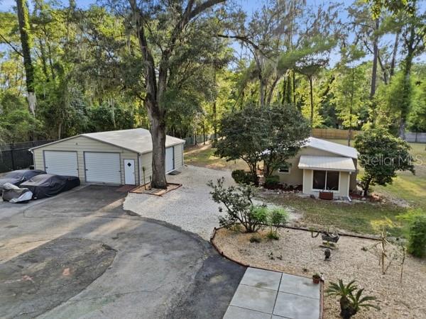 An aerial view shows a detached garage and a house on a wooded lot — 3630 NW 136TH STREET, GAINESVILLE, FL