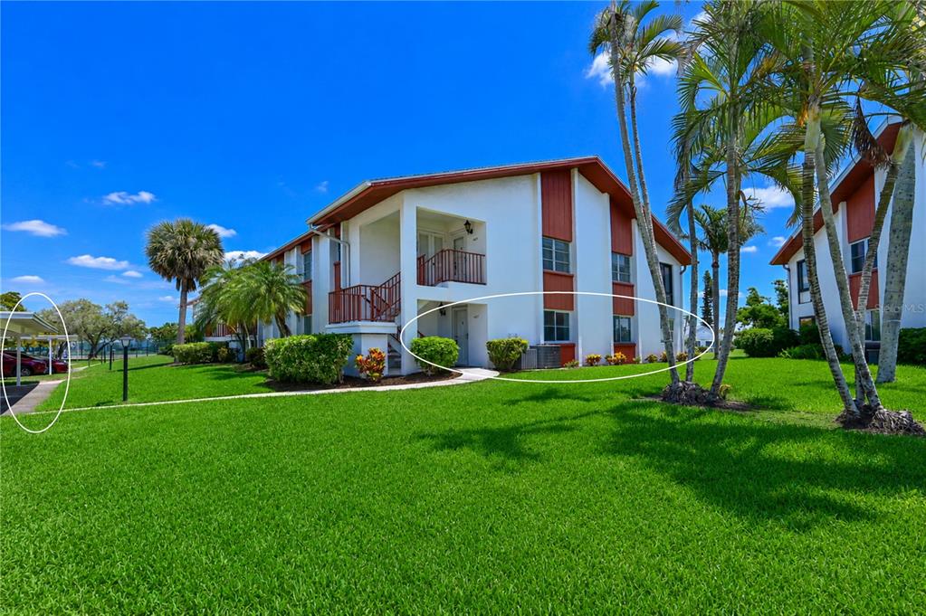 A multi-story apartment building with a covered parking area and landscaped lawn — 4857 INDEPENDENCE DRIVE, BRADENTON, FL