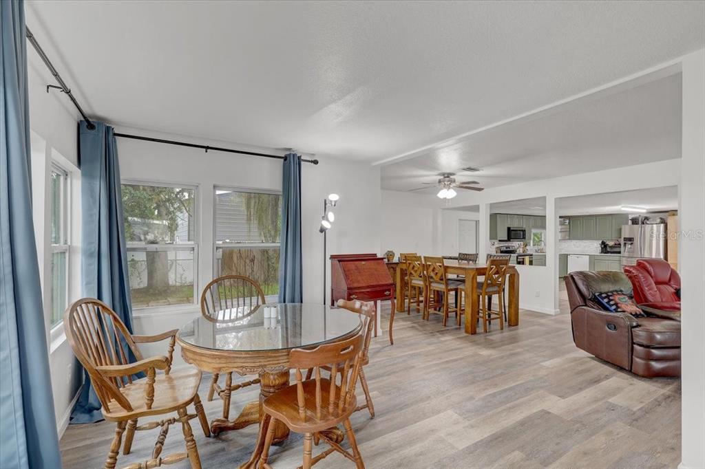 A dining area with a glass-topped table, wooden chairs, and a view into the kitchen — 2557 K VILLE AVENUE, AUBURNDALE, FL