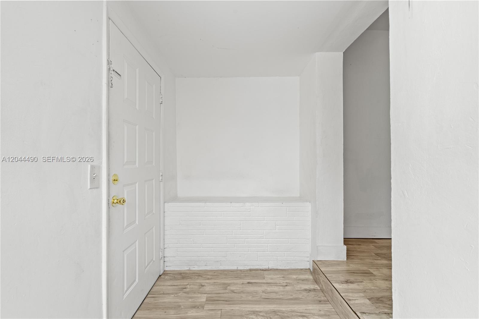 An entryway features a white door, a brick ledge, and light wood-look flooring — 370 NE 55th St, Miami FL 33137, MIAMI, FL