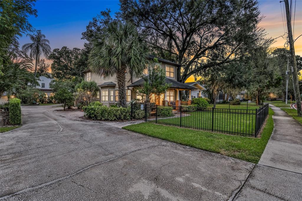 A two-story house with a front porch, fenced yard, and palm tree at sunset — 148 S THORNTON AVENUE, ORLANDO, FL