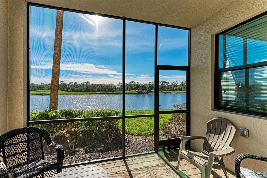 A screened-in patio features a view of a lake and a golf course — 16814 VARDON TERRACE UNIT 103, BRADENTON, FL