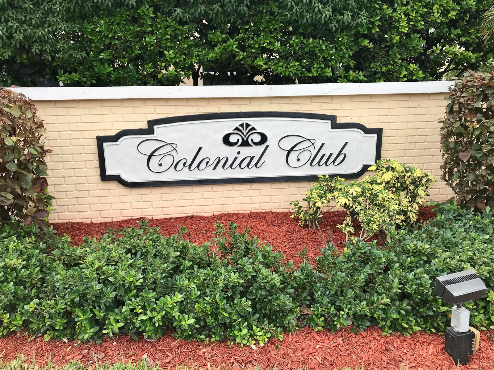A sign reading Colonial Club is mounted on a tan brick wall surrounded by landscaping — 22 Colonial Club Drive # 103, Boynton Beach FL 33435, BOYNTON BEACH, FL