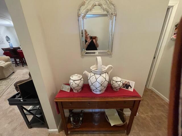 A wooden console table sits below a decorative mirror in a neutral-toned entryway — 22 Colonial Club Drive # 103, Boynton Beach FL 33435, BOYNTON BEACH, FL