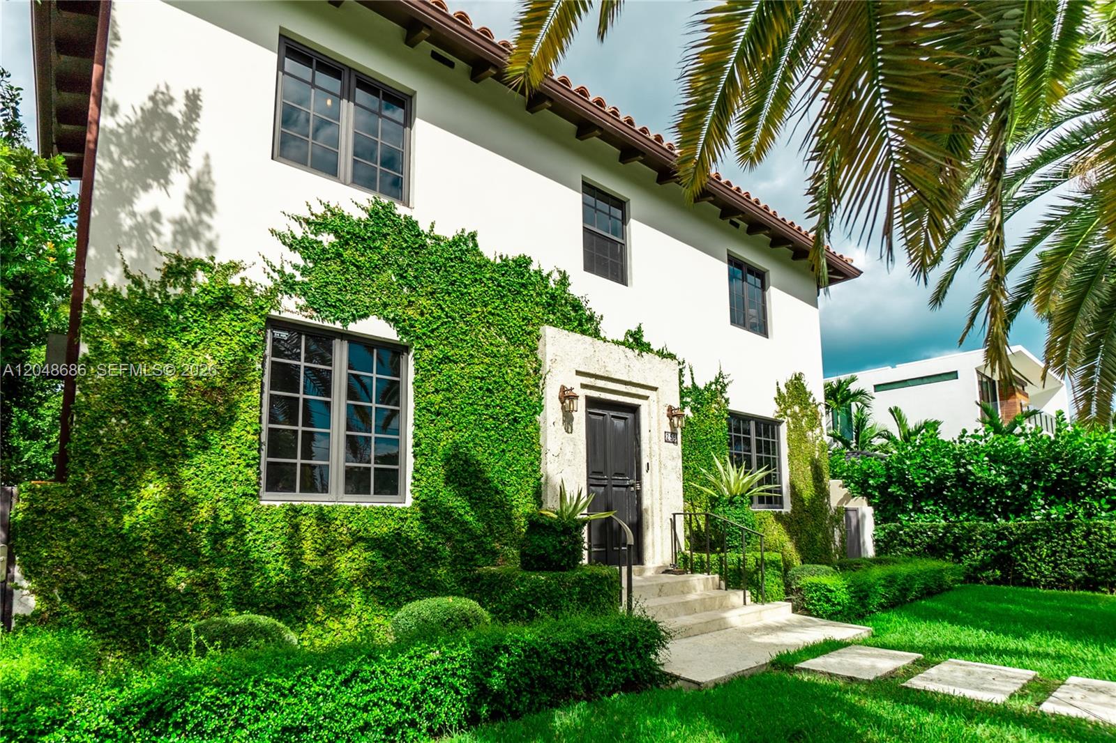 A two-story white stucco house features a vine-covered facade and a stone-framed front entrance — 255 PALM AVENUE, Miami Beach FL 33139, MIAMI BEACH, FL