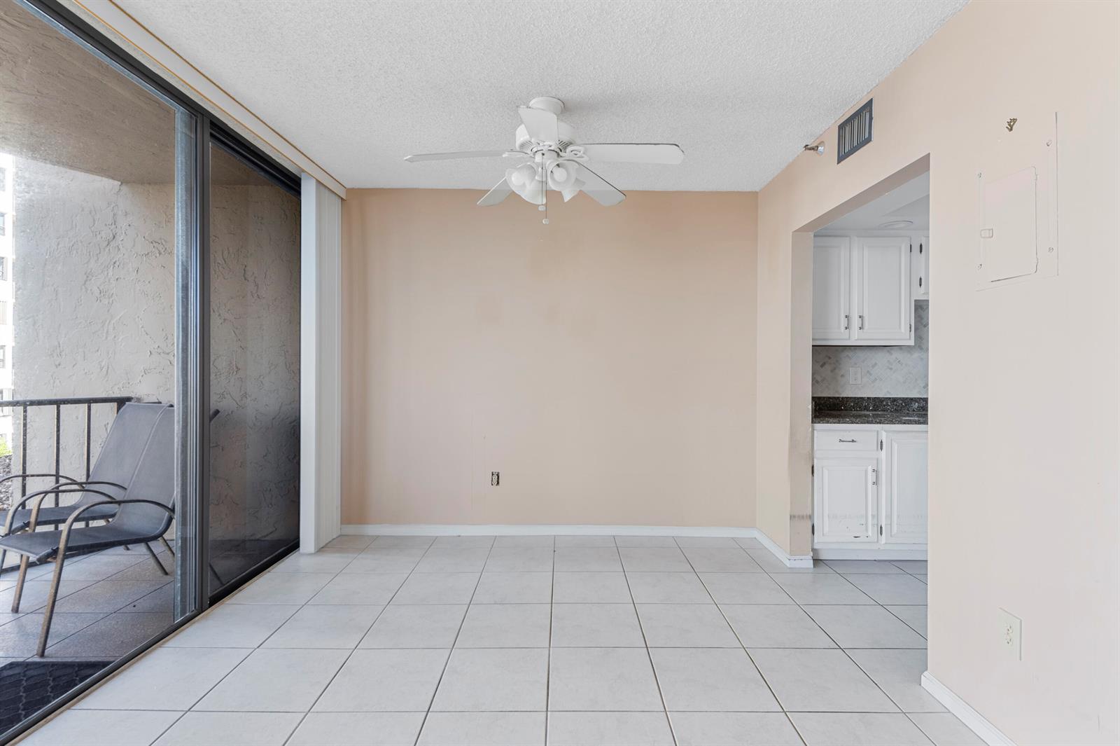 A dining area with tile flooring, a ceiling fan, and a sliding door to a balcony — 859 Jeffery Street # 312, Boca Raton FL 33487, BOCA RATON, FL