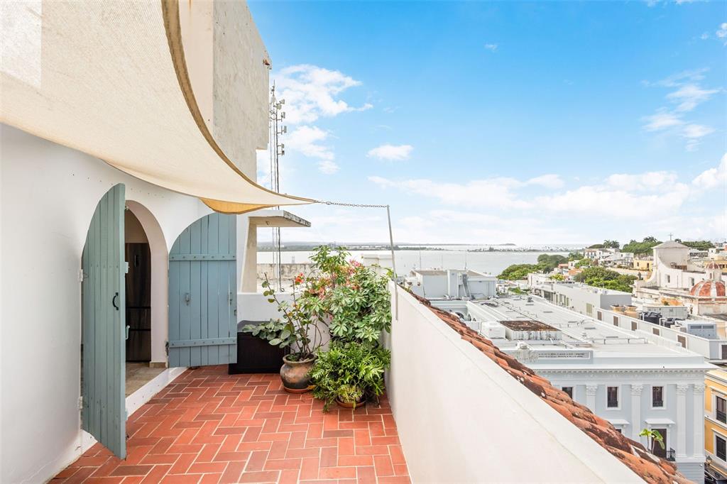A rooftop terrace with terracotta tiles, a shade sail, potted plants, and a city view — 152 RAFAEL CORDERO UNIT PH-2, SAN JUAN, PR