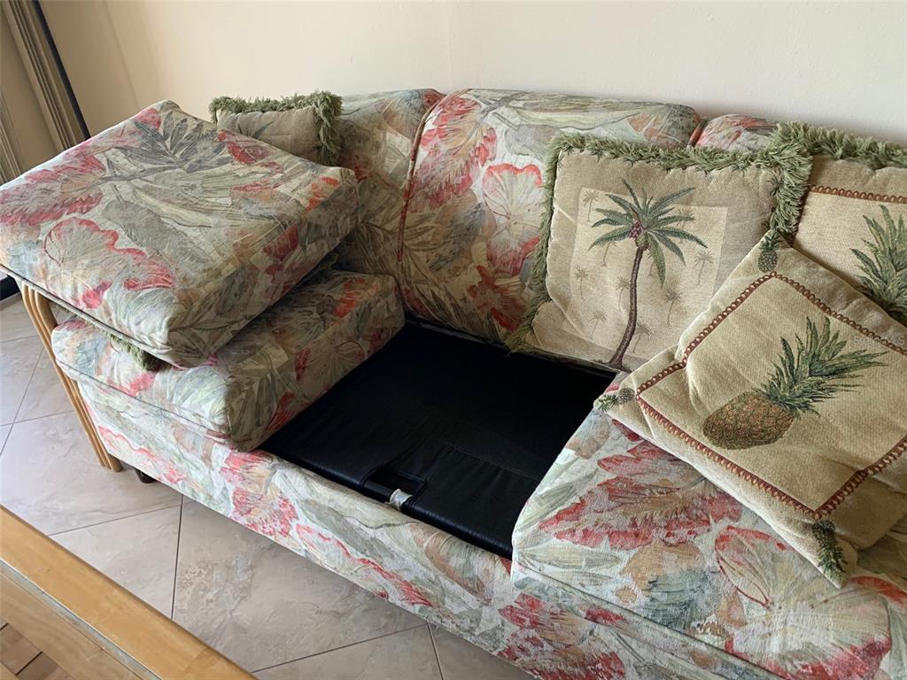 A floral-patterned sofa with loose cushions sits in a room with tiled flooring — 1001 BENJAMIN FRANKLIN DRIVE UNIT 508, SARASOTA, FL